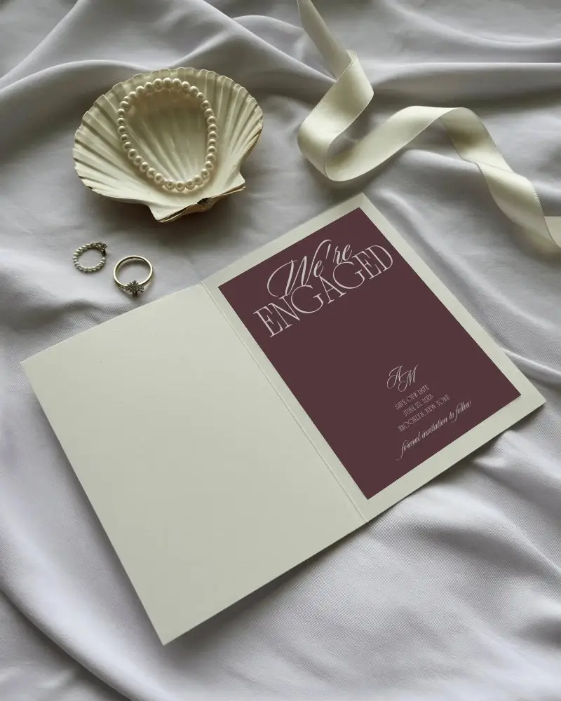 elegant invitation card mockup with pearl accessory and ribbon on soft fabric backdrop